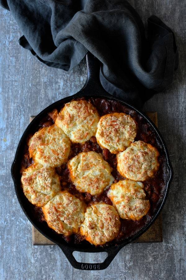 Skillet Turkey and Pinto Bean Chili with Pepper Jack Biscuit Topping Recipe | HeyFood — heyfoodapp.com